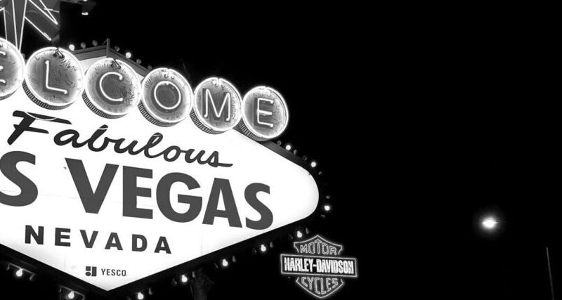 Black and white photo of the famous Las Vegas sign illuminated at night.