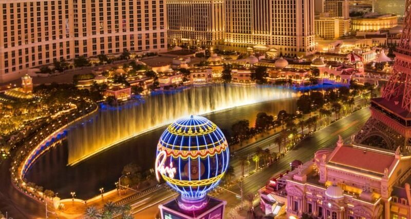 Stunning aerial view of Las Vegas skyline at sunset, featuring the Eiffel Tower and Bellagio fountains.