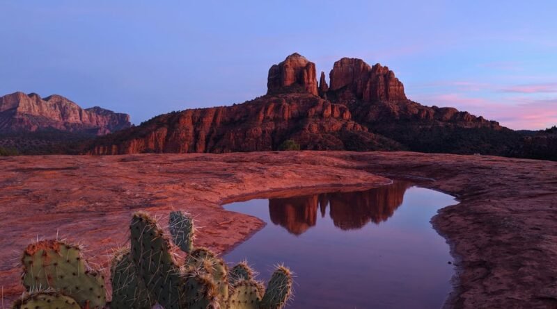 Stunning view of Cathedral Rock in Sedona, Arizona, reflecting in a puddle during sunset.