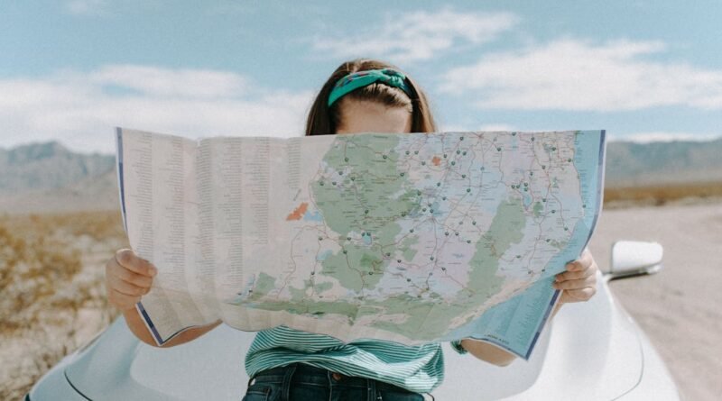 A woman holds a map while traveling through the scenic desert of California, USA.