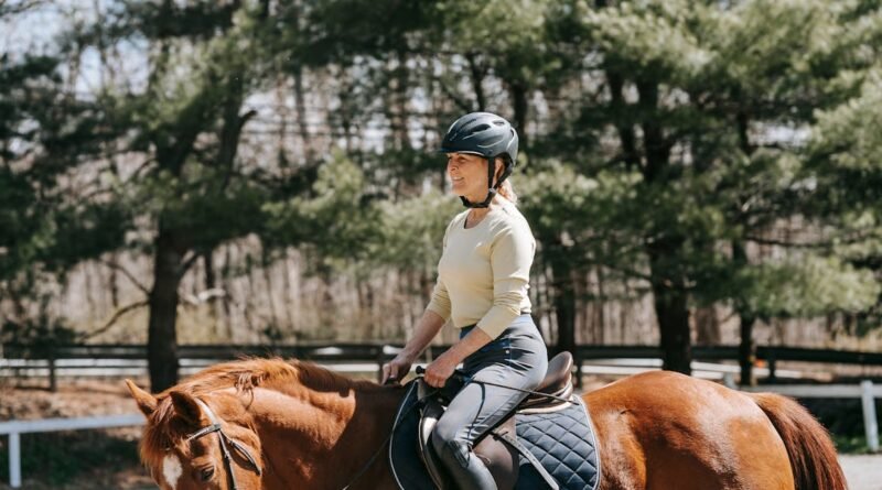 Adult woman enjoying an equestrian ride through a serene wooded area on a sunny day.